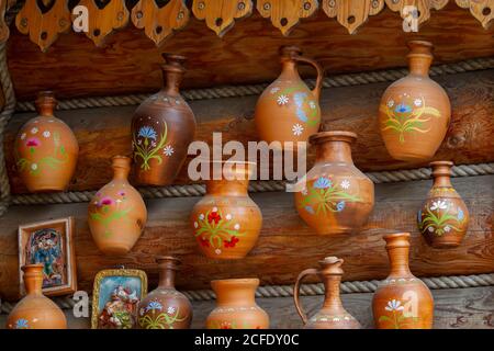 Russland, Moskau, 28. Juli 2018. Izmaylovsky Park. Tonkrüge hängen an einer Holzwand. Stockfoto