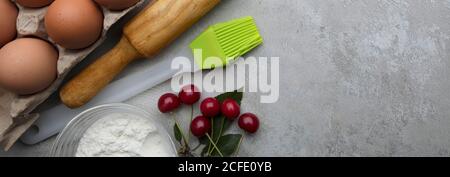 Zutaten für das Backen von Eiern rollende Nadelbeeren auf grauem Hintergrund. Plätzchen oder Kuchen Rezept Mockup. Vorbereitung für das kulinarische Backen. Stockfoto