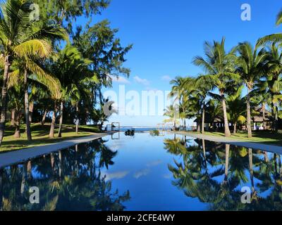 Blauer Pool im tropischen Palmengarten, exotische Insel Mauritius. Erholsamer Urlaub im Luxusresort. Urlaub am paradiesischen Strand. Vergnügen. Ruhe. Stockfoto