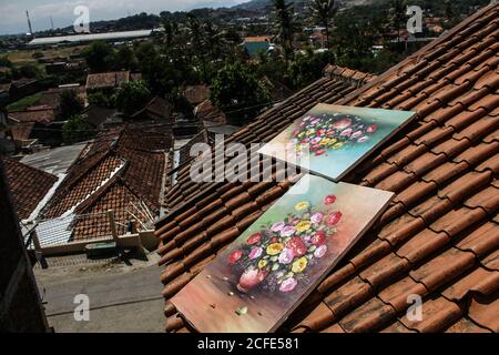 Bandung, Indonesien. September 2020. Blumenbilder werden auf dem Dach eines Wohnhauses im Dorf Jelekong in der Nähe von Bandung getrocknet.die durchschnittlichen Malpreise reichen von IDR 50,000 bis IDR 250,000 (3.39 bis 16.94 Dollar) oder Sonderanfertigungen. Gemälde aus dem Dorf Jelekong wurden in verschiedene Regionen geschickt, vor allem auf die Insel Bali. Aufgrund der COVID-19 Pandemie haben Maler ihre Werke auf dem Online-Markt verkauft. Kredit: SOPA Images Limited/Alamy Live Nachrichten Stockfoto