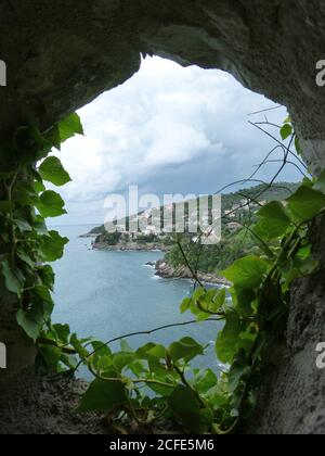 Landschaftlich schöne Aussicht durch Schlupfloch der alten Festung Kalaja auf mediterrane Landschaft der Stadt Ulcinj, Montenegro. Adria. Tolle Meereslandschaft. Sommer. Stockfoto