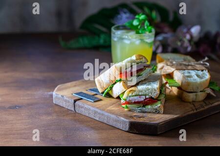 Ciabatta Sandwich mit truthahn, Salat, Tomaten, Käse auf einem Holzbrett. Stockfoto