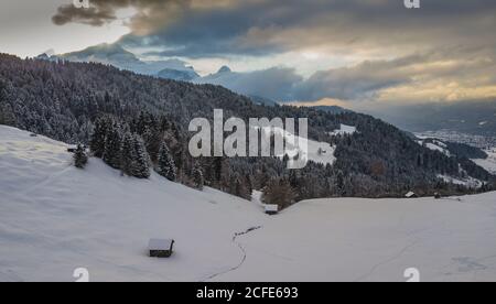 Holzstadel im Winter mit mystischer Wolkenatmosphäre, oberhalb von Wamberg mit Blick auf den Wettersteingebirge bei Garmisch-Partenkirchen, Obere Stockfoto