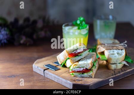 Ciabatta Sandwich mit truthahn, Salat, Tomaten, Käse auf einem Holzbrett. Stockfoto