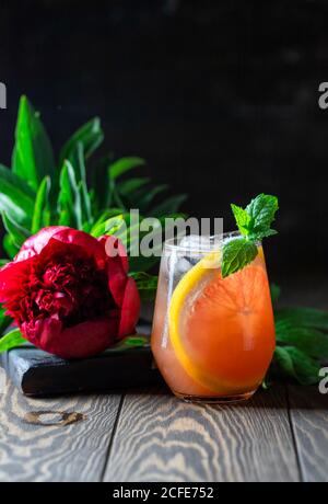 Ein Glas frisch gepresster Grapefruitsaft und Minze auf einem dunklen Holztisch. Erfrischender Sommercocktail. Stockfoto