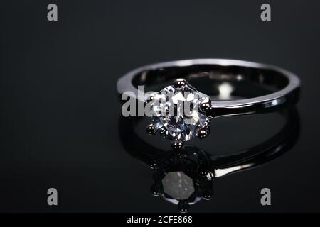 Luxus-Ehering mit großen Diamant-Kristall isoliert auf schwarzem Hintergrund mit Reflect im Spiegel. Stockfoto