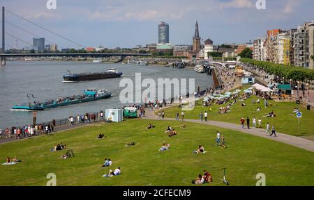 Düsseldorf, Nordrhein-Westfalen, Deutschland - Rheinuferpromenade in Zeiten der Koronapandemie sitzen auf den Rheinwiesen Apollowiese Menschen hinein Stockfoto