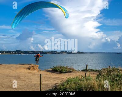 Frankreich - August 2020 - auf der Klippe mit Blick auf den Strand ragt ein Gleitschirm in die Leere, um abzuheben Stockfoto