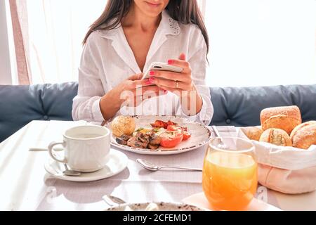 Anonymer Goldschmied verwendet eine Lötlampe, um während des Aufheizs winziges Metallornament zu erhitzen Schmuck auf der Werkbank herstellen Stockfoto