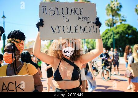Ethnische Frauen protestieren gegen Rassismus in der Stadt mit Schweigen ist Gewalt und schwarze Leben Materie Karton Poster an sonnigen Tag In einer überfüllten Straße Stockfoto