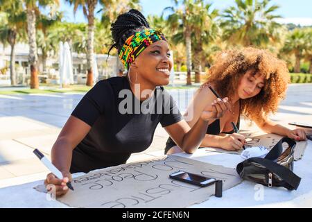 Diverse weibliche Aktivisten machen Plakate mit schwarzen Leben Materie und Keine Gerechtigkeit, keine Friedensinschriften während der Vorbereitung auf den Streik gegen Rassismus Stockfoto