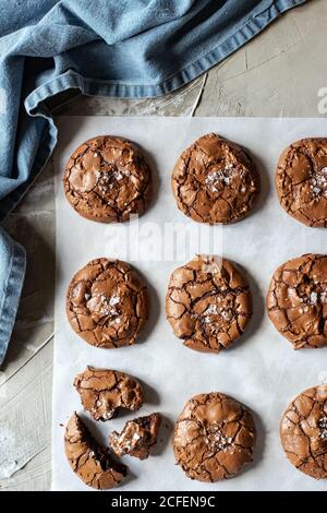 Von oben Zusammensetzung der köstlichen Schokolade Brownie Cookies auf weiß Pergament und blaues Handtuch Stockfoto