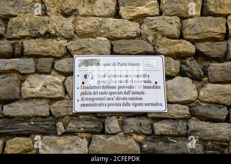 Zeichen auf einer Steinmauer mit den kommunalen Gesetzen für die Hundebesitzer: Verwenden Sie Leine und Schnauze und abholen nach Hund, Porto Venere, La Spezia, Ligurien, Italien Stockfoto