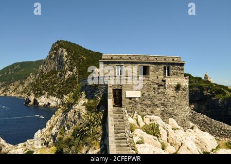 Eine militärische Bastion auf einer felsigen Klippe mit Blick auf das Meer und die Kuppel der Kirche St. Lawrence im Hintergrund, Porto Venere, La Spezia, Italien Stockfoto