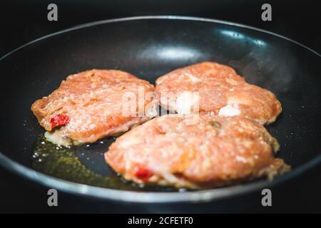 Closeup leckere Fleischschnitzel Braten auf Öl in der heißen Pfanne In der Küche Stockfoto