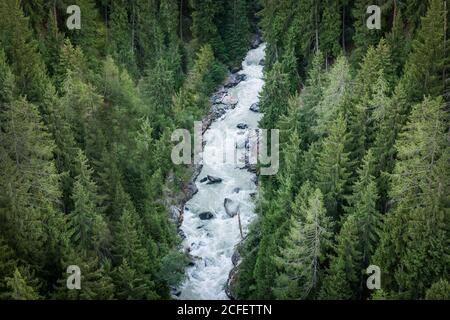 Von oben schnell schäumenden Fluss Bergbach rauscht durch Dutzende Von immergrünen Wäldern in der Schweiz Stockfoto