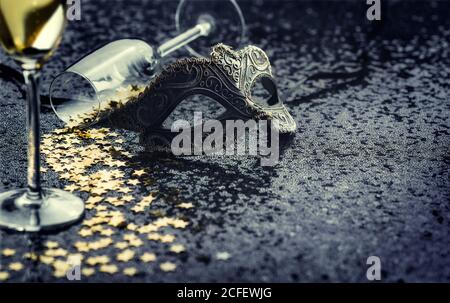 Karnevalsmaske und Glas mit sternförmigen Konfetti. Stockfoto