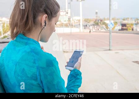 Nahaufnahme einer Frau, die während des Trainings das Smartphone hält Stockfoto