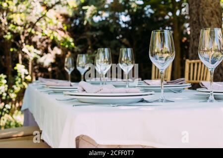 Rustikaler Festtisch im Freien mit Besteck und Gläsern Stockfoto