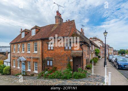 Bakers Arms Cottage, alte kleine rote Backstein Fachwerkhaus neben neueren georgianischen Häusern an der Ecke von Bakers Arms Hill, Arundel, West Sussex, Großbritannien. Stockfoto