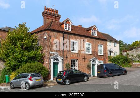 Zweistöckiges Haus aus dem späten 18. Jahrhundert auf einem Hügel mit rotem Backstein, gekacheltem Ziegeldach, Kamin, Dachbodenfenster in Arundel, West Sussex, England, Großbritannien. Stockfoto