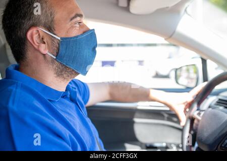 Mann trägt Schutzmaske, um die Infektion von Viren und verschmutzte Luft Ausbreitung Krankheiten in seinem Auto zu vermeiden. Gesundheitswesen, Coronavirus, Influenza Stockfoto