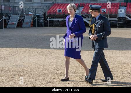 Die britische Premierministerin Theresa May, Politikerin der Konservativen Partei, geht mit Mitgliedern der Streitkräfte in der Horse Guards Parade, Großbritannien Stockfoto