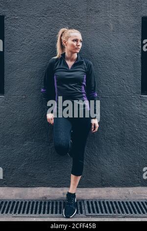Porträt einer jungen blonden kaukasischen Frau mit Sportkleidung im Freien Stockfoto