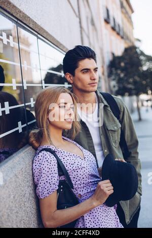 Junge fröhliche Paar in legerer Kleidung Spaß während der Dating Im Freien nebeneinander stehend Stockfoto