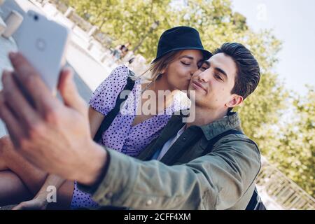 Junge gut aussehende Mann Foto mit Freundin beim Küssen in Wunderschöner Garten Stockfoto