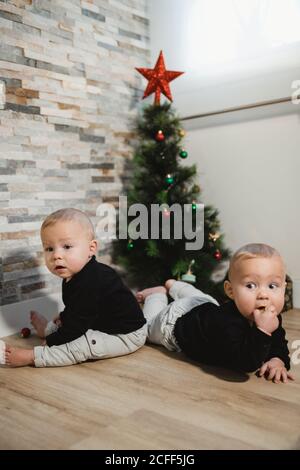 Glückliche Babys in der Nähe von Weihnachtsbaum und Geschenke Stockfoto