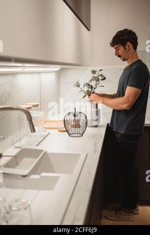 Mann, der Blumen in eine Vase legt Stockfoto