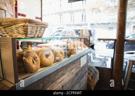 Seitenansicht des Sortiments verschiedener Donuts in der Bäckerei Fenster des Cafés in Paris Stockfoto