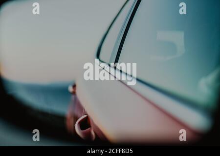 Rotes Fahrzeug, das während der Fahrt im Rückspiegel reflektiert wird Straße an sonnigen Tag Stockfoto