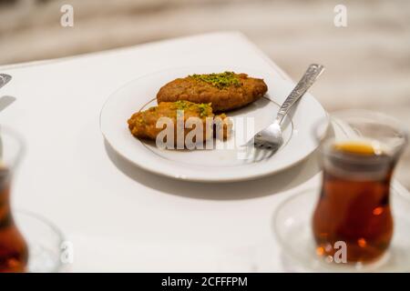 Türkisches Dessert Kalburabasti / Sekerpare mit traditionellem Tee. Bereit zum Essen. Stockfoto