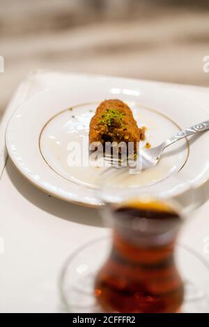 Türkisches Dessert Kalburabasti / Sekerpare mit traditionellem Tee. Bereit zum Essen. Stockfoto