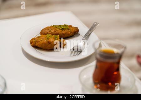 Türkisches Dessert Kalburabasti / Sekerpare mit traditionellem Tee. Bereit zum Essen. Stockfoto