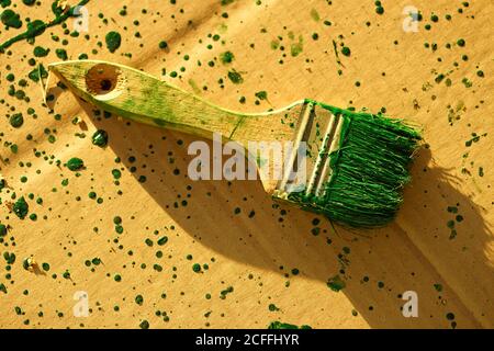 Alte Bürste mit grüner Farbe auf dem schmutzigen Braun gefärbt Papierbogen Stockfoto