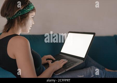 Rückansicht einer Frau, die von zu Hause aus mit ihrem Laptop arbeitet Stockfoto