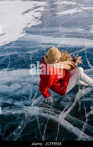 Glückliche Frau in Schlittschuhen, die auf Eis liegt Stockfoto