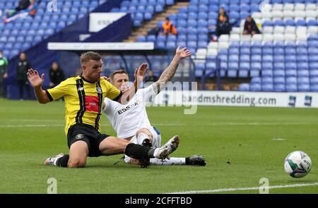 Jack Muldoon von Harrogate Town (links) schießt unter Druck von Peter Clarke von Tranmere Rovers während des ersten Spiels des Carabao Cups im Prenton Park, Birkenhead. Stockfoto