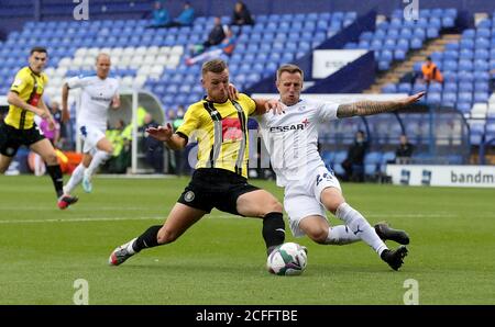 Jack Muldoon von Harrogate Town (links) schießt unter Druck von Peter Clarke von Tranmere Rovers während des ersten Spiels des Carabao Cups im Prenton Park, Birkenhead. Stockfoto