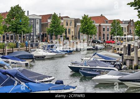 Oud-Beijerland, Niederlande, 10. Juli 2020: Der Yachthafen der Stadt mit kleinen Yachten und Schlinge und im Hintergrund eine Reihe von traditionellen Häusern Stockfoto