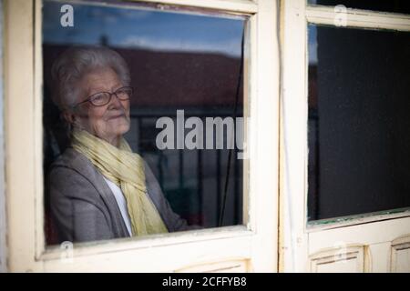 Ältere Frau mit Blick aus dem Fenster Stockfoto