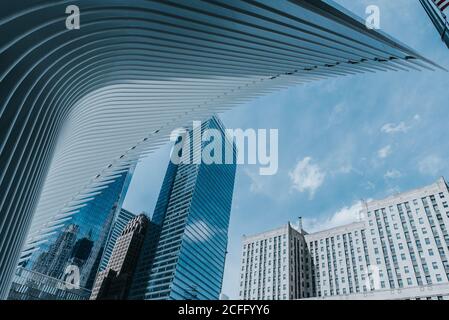 Von unten von zeitgenössischen Wolkenkratzern mit gläsernen Spiegelwänden und Futuristische Konstruktion auf dem Hintergrund des blauen Himmels Stockfoto