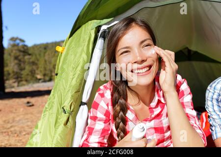 Camping Frau Anwendung Sonnencreme im Zelt Stockfoto