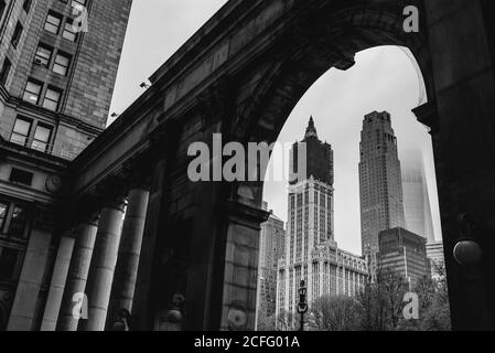 Von unten die schwarz-weiße Stadtlandschaft des Woolworth Building Unter Wiederaufbau und Stein gewölbten Durchgang mit Säulen in Manhattan Stockfoto