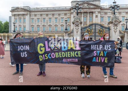 London, UK, UK. September 2020. Klimaaktivisten der Extinction Rebellion inszenieren einen „Discobedience“-Protest vor dem Buckingham Palace und halten ein Banner, das globale Klimaschutzmaßnahmen fordert. Extinction Rebellion Protest im Buckingham Palace. Die Veranstaltung trägt den Namen „Discobedience“. Penelope Barritt/Alamy Live News Stockfoto