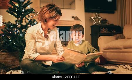 Mutter liest Buch mit Sohn am Heiligabend Stockfoto