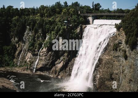 Malerische Landschaft mit einsamen Aussichtsplattform über die Kaskade am Fluss Fallen von felsigen Klippen zwischen grünen dichten Wald unter klaren Blauer Himmel Stockfoto